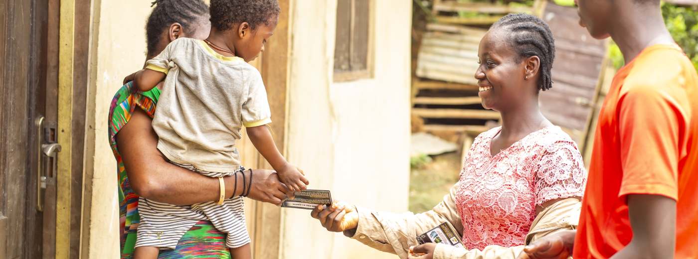 Sharing the Gospel at the door during the Dompim community outreach.