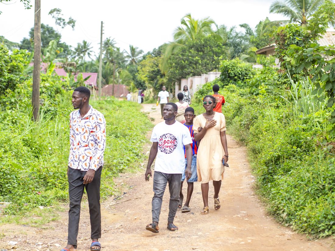The Harvest Crew walking a village path on the way to the next home