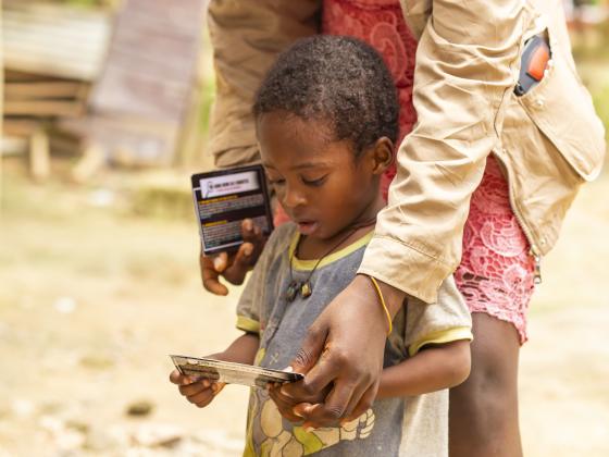 A child with a Gospel tract at Dompim