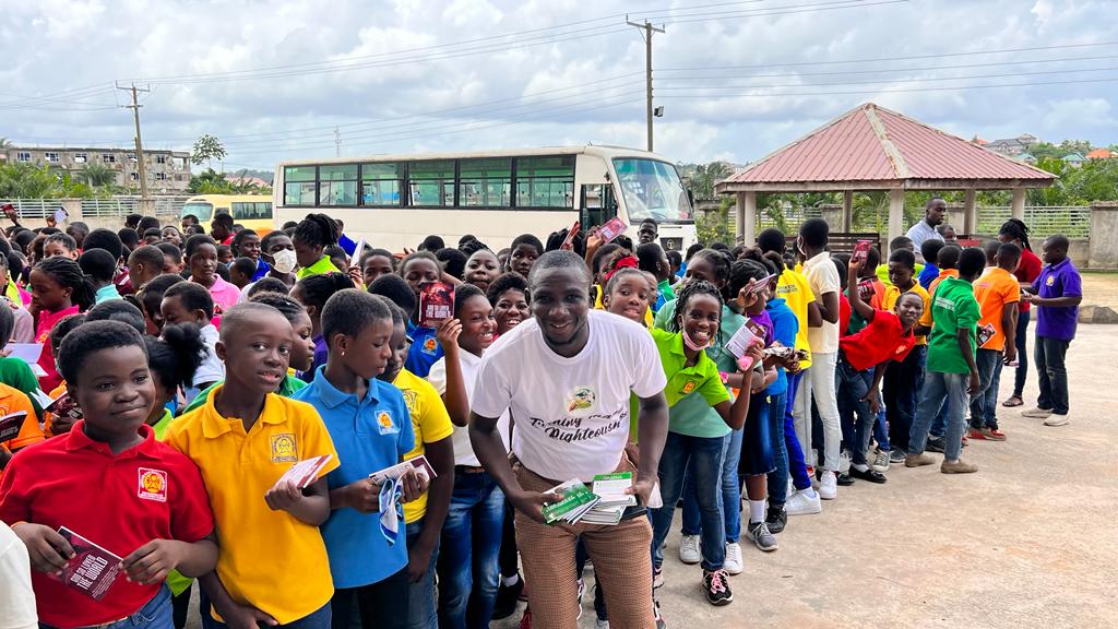 Students receiving Gospel literature during a school outreach